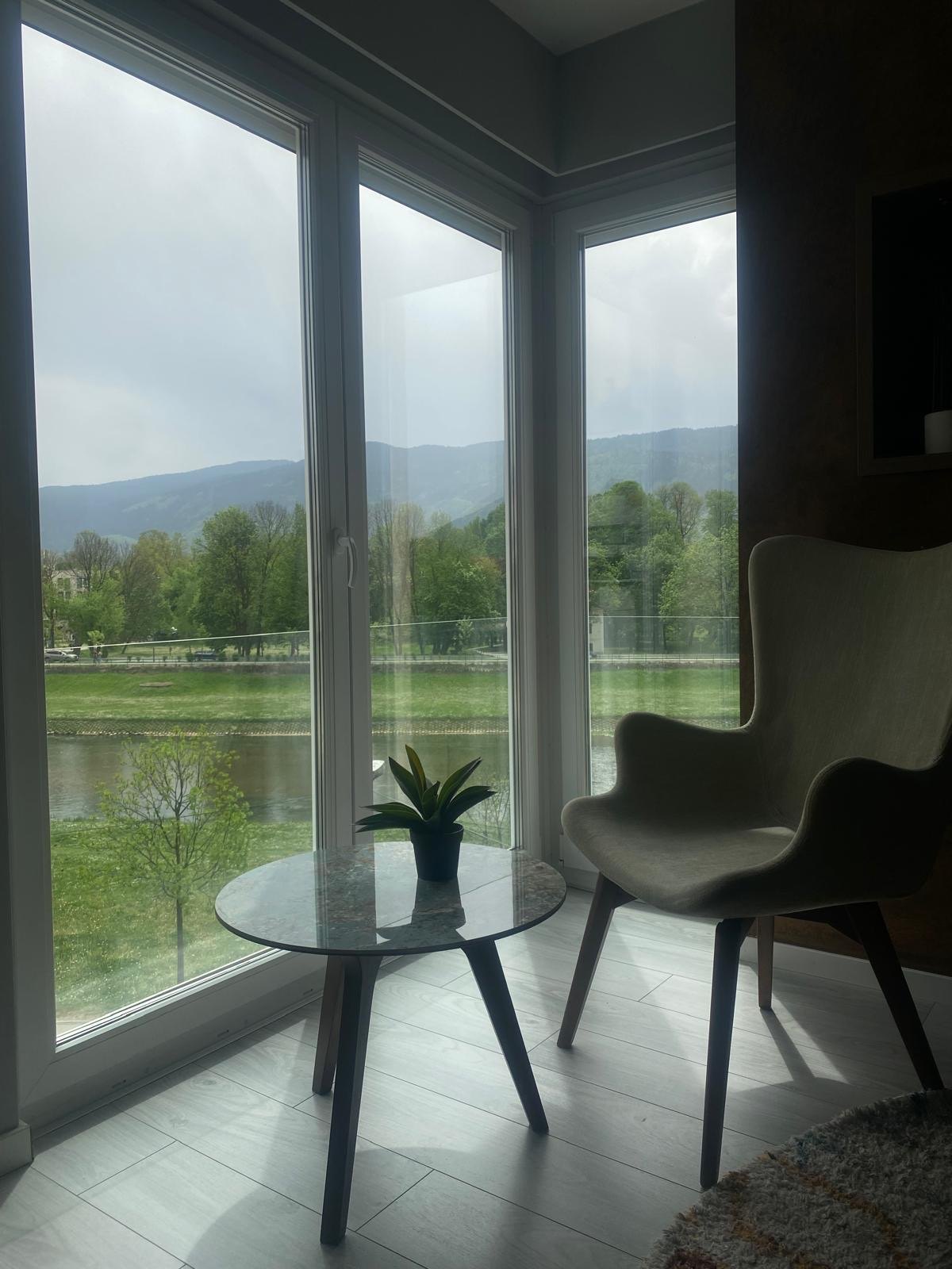 Kutak za odmor u Delux apartmanu s velikim prozorima i pogledom na rijeku